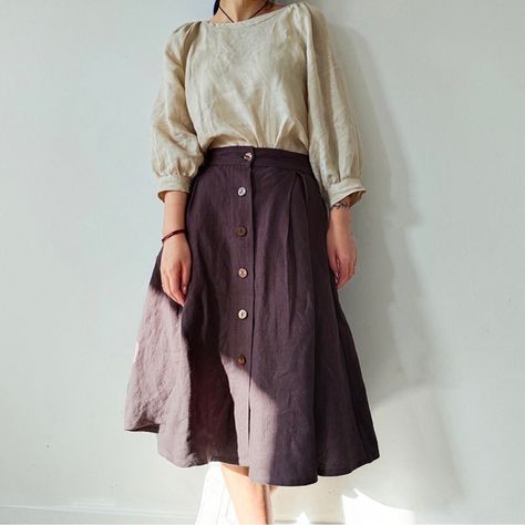 "This Button Front Linen Skirt with Pockets is a beautiful vintage-inspired piece that combines style and functionality. Made from high-quality linen fabric, this A-line skirt features a midi length, which falls just below the knee. The washed finish gives it a relaxed, casual vibe that makes it perfect for everyday wear. The skirt is designed with a button front closure, which adds a touch of elegance and sophistication to the overall look. The buttons are placed asymmetrically, creating an int Skirt With Button Up Shirt, Button Down Shirt With Skirt, Plain Skirt Outfit, Knee Length Skirt Outfit, Vintage Cottagecore Outfits, Linen Skirt Outfit, Midi Rock Outfit, Midi Skirt Outfits, A Line Skirt Outfits