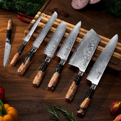 Impeccable Craftsmanship meets Artistic Mastery with the Tsunami Black Damascus Knife Collection. The Tsunami Black Collection features seven individually forged Damascus kitchen knives made of 67-layer Japanese Damascus Steel with a HRC Rating of 62 for unparalleled hardiness and performance. 33-layers of Damascus on each side surround the Japanese VG10 Steel Core. Built to last and retain sharpness so that you will never need another set of knives again. Each knife has a stunning Black Resin B Japanese Cooking Knives, Japanese Kitchen Knife, Knife Aesthetic, Kitchen Knives Set, Damascus Kitchen Knives, Japanese Kitchen Knives, Kitchen Knife Set, Japanese Chef, Chef Knife Set