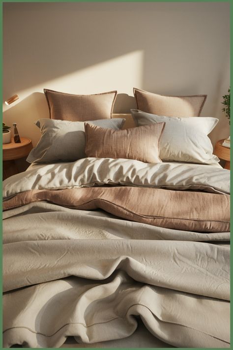 Cozy bed with beige and brown pillows and a fluffy comforter, bathed in soft natural light. Organic Bedding, Bamboo Bedding, Eco Friendly Design, Energy Efficient Lighting, Sustainable Lifestyle, Sustainable Home, Upcycled Furniture, Cotton Bedding, Sleep Comfortably