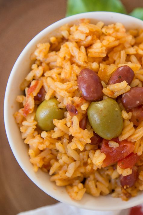 Close-up of a bowl of Instant Pot Puerto Rican rice and beans featuring fluffy seasoned rice, tender red beans, and briny green olives, showcasing a vibrant and hearty dish perfect for quick family dinners. Puerto Rican Stewed Beans, Puerto Rican Pink Beans Recipe, Rice And Beans Recipe Puerto Rican, Puerto Rican Rice And Beans, Puerto Rican Beans, Stewed Beans, Puerto Rican Rice, Rice And Beans Recipe, Fried Plantains