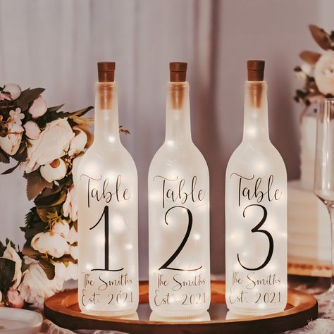 Wedding Table Numbers - Event Table Centerpieces - Vineyard Wedding Decor - Garden Wedding Decor - Wine Bottle Lights - Rehearsal Dinner | MakerPlace by Michaels Wine Bottle Table Numbers Wedding, Event Table Centerpieces, Wine Bottle Wedding, Unique Table Numbers Wedding, Vineyard Wedding Decor, Garden Wedding Decor, Wine Bottle Lights, Wine Bottle Centerpieces, Rustic Wedding Table Decor