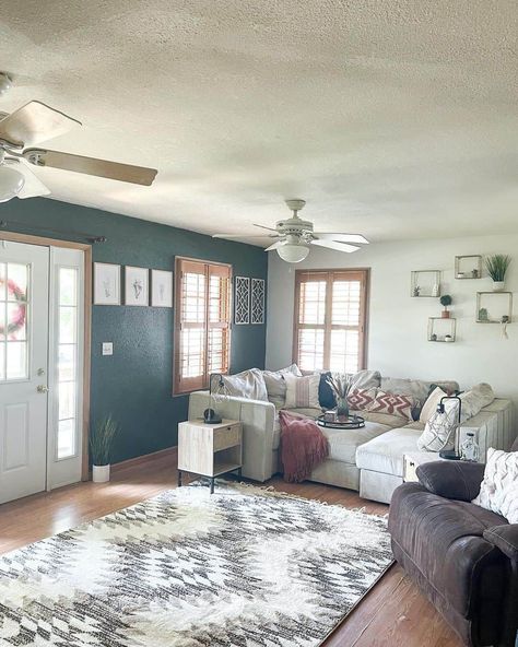 A dark teal gray accent wall adorned with famed prints is the focal point of this cozy living room. The rest of the room is styled with a soft gray couch, patterned pillows, and a white and gray rug to create a sense of cohesion. Plenty of natural light from the windows helps the dark accent wall from appearing too dark...   Image: hickoryridgecharm Teal Accent Wall, Hutchinson House, Gray Accent Wall, Dark Accent Wall, Teal Accent Walls, White Built Ins, Dark Accent Walls, Gray Couch, Gray Living Room