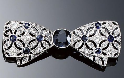 SAPPHIRE AND DIAMOND BROOCH, 1920S.  Designed as a tied bow, centring on a cushion-shaped sapphire to ribbons pierced with a flower head design highlighted with single- and rose-cut diamonds and circular-cut sapphires. Tie Jewelry, Bijoux Art Deco, Swarovski Crystal Hearts, Ribbon Jewelry, Bow Brooch, Bow Jewelry, Diamond Brooch, Royal Jewels, Head Design