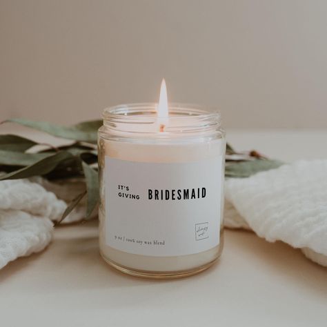 Light up the bridal party with our "It's Giving Bridesmaid" candle, the perfect gift for your closest friends on your big day. This candle is crafted with a luxurious blend of scents that capture the essence of elegance and celebration. Whether you're asking them to stand by your side or thanking them for doing so, this candle is a chic and thoughtful way to show your appreciation. Great for: - Bridesmaid Proposal Boxes - Bridal Shower Gifts - Wedding Party Favors - Thank You Gifts for Bridesmaids ✨ Product Details: Infused with 100% premium soy wax & a 100% cotton wick for a clean and even burn, this 9 oz candle delivers a comforting, long-lasting fragrance that makes any space feel cozy and inviting. - Glass jar  - Black Metal cap  - Dimensions: 2.8" wide x 3.5" tall (7.1cm × 8.9cm) - Bu Bridesmaid Candle, Proposal Boxes, Wedding Shower Gifts, Gifts Bridesmaid, Bridesmaid Box, Proposal Box, Bridesmaid Proposal Box, Wedding Party Favors, Gifts For Wedding Party