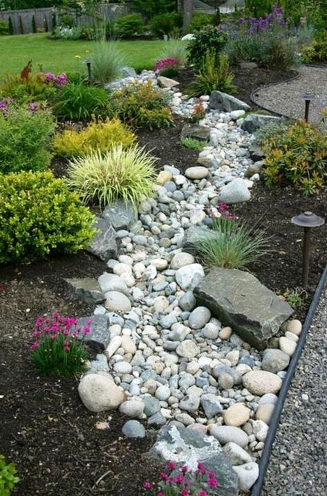 a beautiful and low maintenance garden incorporating a river rock dry stream with herbs and blooms around Stream Landscaping, Dry Stream, River Rock Garden, River Rock Landscaping, Small Front Yard Landscaping, Rock Garden Design, Creek Bed, Front Yard Design, Dry Creek