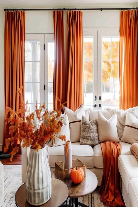 Living room with orange fall curtains, white sofa, and seasonal decorations. Matching Curtains In Living Room, Green Couch Orange Curtains, Curtains To Go With Orange Sofa, Autumn Curtains Living Room, Fall Curtains Living Rooms, Orange Curtains Living Room, Orange Boho Curtains, Luxury Orange Traditional Drape Sets, Fall Curtains