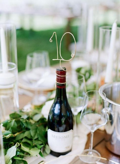 Simplify your centerpieces and stand your table number high for guests to see with these stylish wire wine bottle table numbers. Perfect to guide your guests to the correct table at your wedding and works great on any style bottle. Perfect for winery weddings, vineyard events, or champagne bottle toasts. The set includes 5 pieces. INCLUDES: This listing includes 5 wine bottle table numbers made out of lightweight 12 gauge aluminum wire. The wire numbers measure approximately 3 inches tall and are flexible enough to fit almost any size bottle. USES: These table numbers are not free-standing but will adjust to fit atop any size bottle. PROCESSING & SHIPPING: Orders are processed in 2-5 business days from the date the order is placed. And shipping takes 2-5 days via USPS First Class Mail. Upg Full Wine Bottle Centerpieces, Wine Wedding Table Setting, Wine Bottle Centerpieces For Wedding Diy, Champagne Bottle Centerpiece, Wine Bottle Centerpieces For Wedding, Wine Themed Wedding Centerpieces, Vineyard Wedding Centerpieces, Tall Table Numbers, Wine Bottle Table Numbers