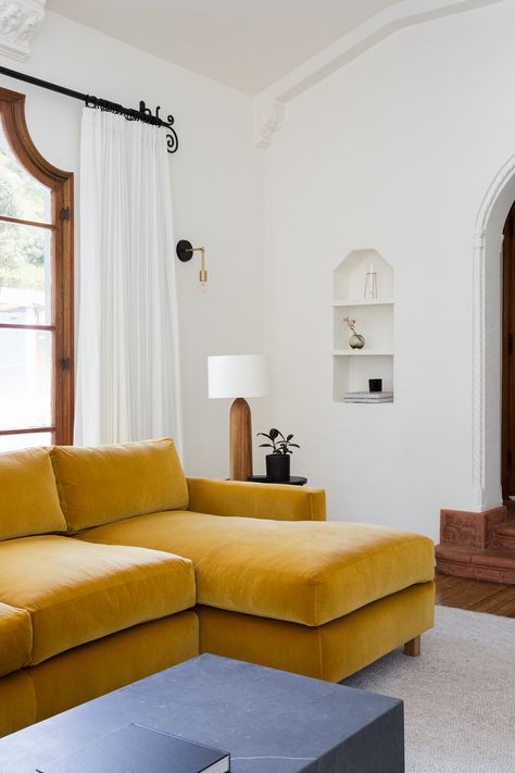 This Spanish-style house fits right in to the charming Los Angeles neighborhood of Los Feliz, with elements in each room mixing vintage, custom, and crafted pieces, ensuring that each space pays homage to the original architecture of the home while still feeling modern and edgy. Marigold Sofa Living Room, Marigold Velvet Sofa, Marigold Living Room, Marigold Sofa, Yellow Couch Aesthetic, Yellow Couch Living Room Ideas, Quirky Living Room, House Fits, Apartment Living Room Decorating Ideas