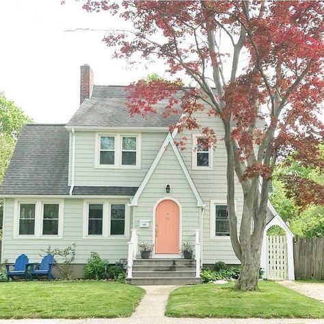 This classic cottage uses pops of color by adding a fun peach color to the front door and royal blue chairs. New England Homes Exterior, Exterior House Paint Schemes, Benjamin Moore Exterior Paint, House England, Green House Exterior, Best Exterior House Paint, Benjamin Moore Exterior, Best Exterior Paint, Farmhouse Paint Colors