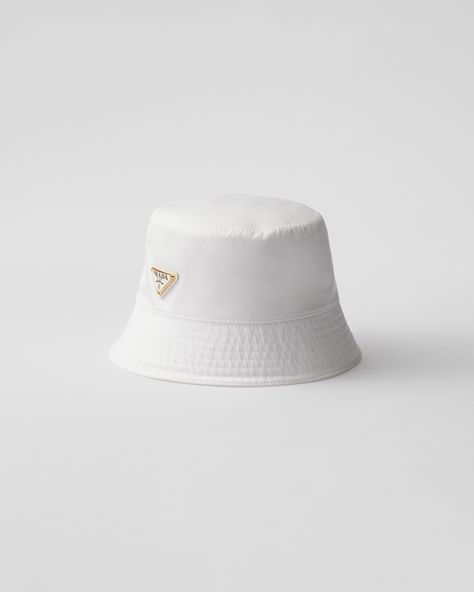 This bucket hat, an iconic accessory of Prada collections, is made of Re-Nylon: regenerated nylon yarn (ECONYL®)produced from recycled, purified plastic trash collected in the ocean, fishing nets and textile waste fibers. For sustainable care to preserve the product's characteristics and reduce microfiber shedding, we recommend not washing the item too often. Let the product air out after every use and have it dry cleaned at a specialized ecological dry cleaners. White Bucket Hats, Re Edition Prada, Prada Hat, Plastic Trash, Bucket Hat White, Textile Waste, Prada Collection, Ballerina Slippers, Ocean Fishing