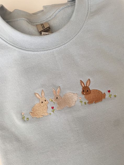 "Embroidered Bunnies Sweatshirt -Embroidered on a cotton/polyester blend crewneck sweatshirt, this design is simple and minimalistic, perfect for every outfit! -Embroidery design measures 4.5\" x 3\". -See product pictures for shirt sizing chart. **SWEATSHIRTS ARE IN UNISEX SIZING AND RUN TRUE TO SIZE. -All sweatshirts are handmade on an embroidery machine so there may be slight differences, but we only sell the sweatshirts that meet our high-quality standards. -To maintain the quality of your sweatshirt and the embroidery design make sure to wash with care. We recommend turning the item inside out and using a cold wash and delicate cycle. We highly recommend air drying when possible as well. -Please feel free to reach out with any additional questions, customization requests, etc. We will Aesthetic Embroidered Sweatshirt, Embroidery Shirt Ideas, Embroidery Shirt Designs, Embroidery Machine Ideas, Sweatshirt Embroidery Diy, Embroidery Shirts, Embroidery Machine Designs, Embroidery Shirt, Sweatshirt Embroidery Ideas