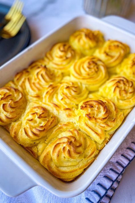 white casserole dish with golden brown swirls of mashed potatoes across the top