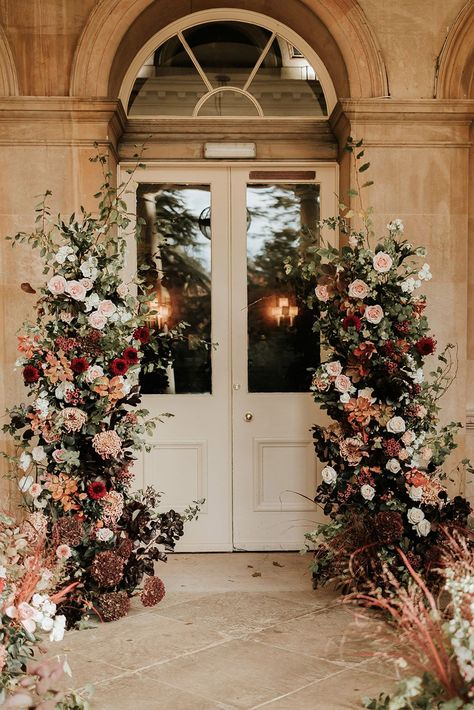 Pale pink and red autumnal wedding flower column decorations Fall Flower Arch Wedding, Blush Autumn Wedding, Moody Wedding Ceremony Decor, Fall Floral Arch Wedding, Wedding Flower Tower, Wedding Flowers Autumn, Cedar Rose Wedding, Flower Columns Wedding, Dark Spring Wedding