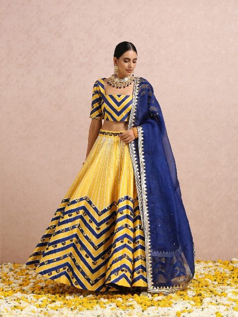 Featuring an ink blue and yellow colourblockedlehenga with gota and hand embroidered folded sequins.It comes with a colourblocked embroidered blouse. It is paired with an ink blue embroidered silk organza dupatta. Color: Yellow and Ink Blue Fabric: Lehenga & Blouse - Silk base Dupatta - Silk Organza Note: The product will be shipped within 30-35 days of order placed Wash care - Dry Clean Only. Do not use heavy Iron Yellow Sets With Gota Work For Transitional Season, Yellow Sets With Gota Work For Seasonal Transition, Transitional Yellow Sets With Gota Work, Transitional Yellow Chanderi Choli, Transitional Yellow Lehenga With Cutdana, Yellow Choli With Dori Work For Eid, Transitional Yellow Anarkali Lehenga, Semi-stitched Yellow Choli For Transitional Season, Eid Yellow Choli With Dori Work