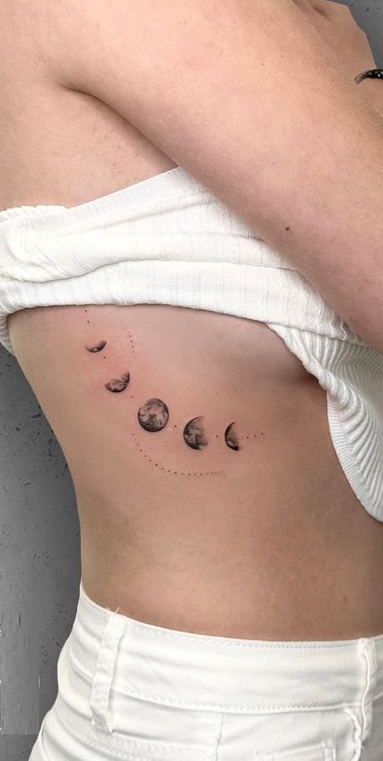 << Check out more Moon Phase Tattoos, Ideas and Meanings #tattoomenow #tattooideas #tattoodesigns #tattoos #Moonphase #Moonphasetattoo Moon Phase Back Tattoo Women, Moon Phase Tattoo Ribs, Planets Down Spine Tattoo, Moon Changes Tattoo, Moon Phases Tattoo Lower Back, Ribcage Moon Tattoo, Stages Of The Moon Tattoo, Women Ribcage Tattoo, Moonphase Tattoo Design