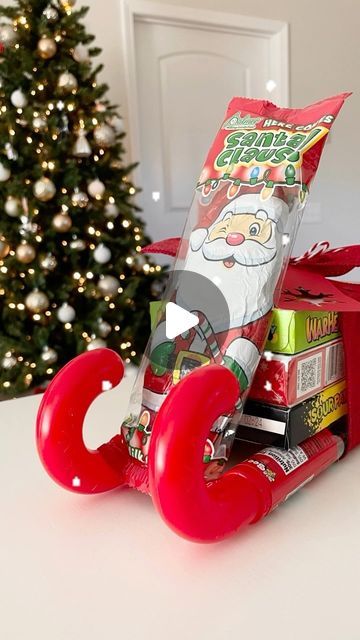 Emma Villaneda on Instagram: "🎄Pt.2 of Dollar Tree gift ideas for teachers, neighbors, coworkers, family/friends, or really anyone. 🎁🎁🎁 Sharing a fun way to gift candy! Make sure you follow for more so you don’t miss out! Materials: - 2 filled Candy Canes (Dollar Tree) - 3 candy boxes (Dollar Tree) - Chocolate Santa (Dollar Tree) - Ribbon • • • • #christmas #christmasdecor #santaclaus #sleigh #christmasgift #gingerbread #christmastime #holiday #holidaydecor #diy #craft #homedecor #design #home #interior #homedesign #interiordesign #gift #giftideas #explorepage #trending #reelvideo #newreel #art #dollartree #dollarstore #creative #santa #chocolate #candy" Candy Christmas Sleighs, Christmas Chocolate Sleigh, Candy Sleigh Craft, Hershey Christmas Tree, Candy Sleigh Gift Card Holder, Christmas Candy Sled Ideas, Candy Santa Sleigh Diy, Candy Bouquet Christmas Diy, Christmas Candy Sleigh Diy