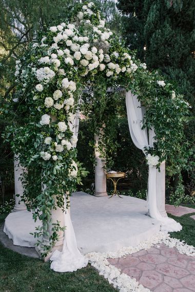 Draped white fabric and a structure of white roses and hydrangea was perfect for this classic outdoor wedding. | Design by Hidden Garden Flowers, Photo by Amy & Stuart Photography Altars Ideas, Jewish Wedding Traditions, Wedding Chuppah, Rustic Wedding Backdrops, Ceremony Aisle, Classic Elegant Wedding, Wedding Canopy, All White Wedding, Ceremony Decor