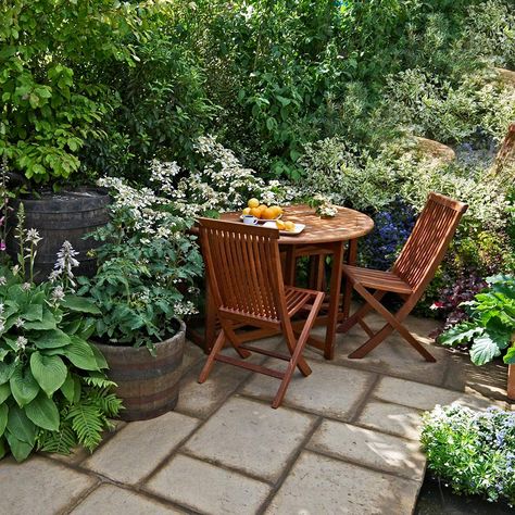 A patio table and chair in a small garden Long Narrow Backyard, Small Garden Table And Chairs, Narrow Backyard, Small Outdoor Table, Home Gardening Ideas, Garden Sitting Areas, Small Table And Chairs, Corner Ideas, Garden Corner