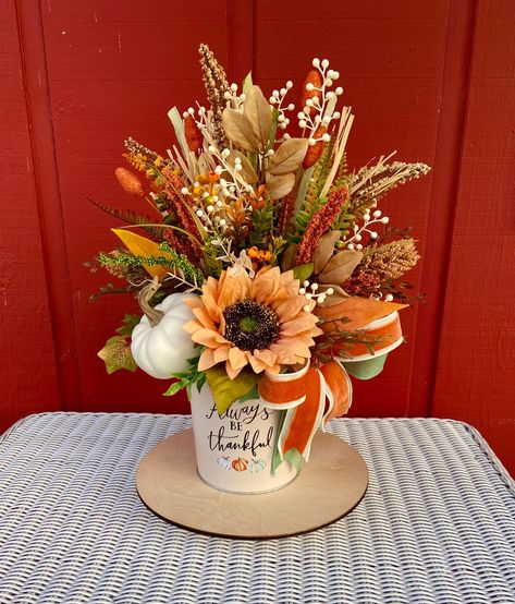 Small Fall/Thanksgiving centerpiece in decorative metal container. The arrangement is designed with assorted sunflowers, fall foliage and more. *SIZE: The size is approximately 17" tall and 10" wide. *PROCESSING TIME: Your item will ship within 1 to 2 business days after purchase. *GIFTS: You can ship your selection directly to your gift recipient. I will be happy to include a complimentary gift note. Please let me know in the notes to seller field upon checkout. Small Fall Arrangements, Small Fall Centerpieces For Table, Thanksgiving Flower Arrangements, Thanksgiving Floral Arrangements, Hostess Gifts Thanksgiving, Thanksgiving Hostess, Thanksgiving Flowers, Thanksgiving Floral, Fall Floral Arrangements