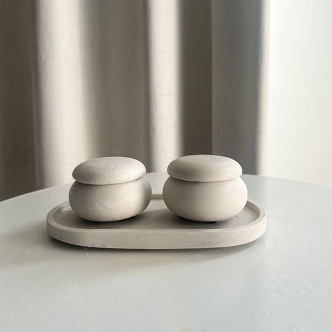 Upgrade your home decor with this minimalist salt and pepper pinch tray set! This stone oval tray and round concrete jars food safe, sealed and protected for your daily needs ! It also makes for a great Mother's Day gift, first apartment gifts, new home gift, or host and hostess gift idea.  ♻️ Unlike most others, our stone tray is food-safe and made from eco-friendly materials ♻️ 🤍The cement tray measures at: 🤍 This handmade set like all of Urban Stone Designs , they are also very functional w Minimalist Dinnerware, Concrete Jars, Salt And Pepper Bowls, Apartment Gifts, First Apartment Gift, Cement Tray, Ceramica Ideas, Stone Tray, Organizing Stuff