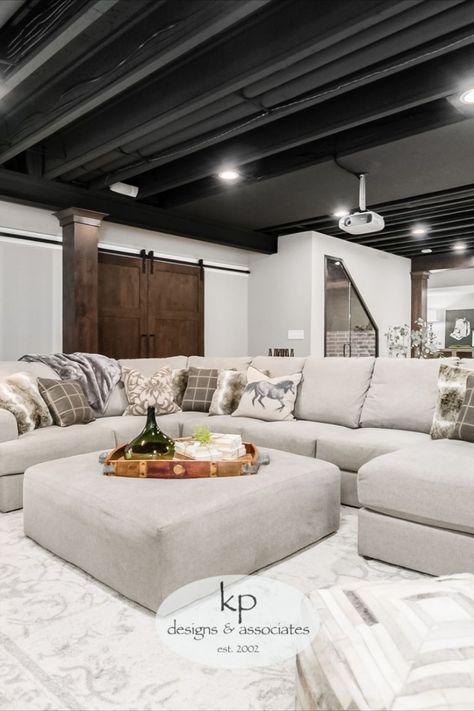 The client wanted to trade out their unfinished basement for a casual hangout where they could entertain and connect. The design inspiration was industrial with a touch of traditional to tie into the upstairs aesthetic. The entire lower level was renovated, adding a bedroom, bathroom, bar, and TV projector room. The finishes include traditional wainscotting and sconces in the TV area, an exposed ceiling, cold wine storage under the stairs... Upstairs Aesthetic, Projector Room, Exposed Basement Ceiling, Industrial Basement, Open Basement, Low Ceiling Basement, Exposed Ceiling, Learning Clock, Small Basement Remodel