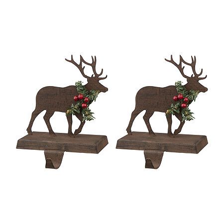 Celebrate the holiday with this Wooden Metal Reindeer Stocking Holder. The holder features green garlands and four red berries adorn the deer's neck. A beautiful way to hang your stockings on your mantel this Christmas!# Pieces In Set: 2Included: 2 Stocking Holder(s)Power Source: Battery (not Included)Use: IndoorMeasurements: 5.12 Depth/Inches, 6.5 Height/Inches, 3.94 Width/InchesWeight (lb.): 1 LbBase Material: 50% Iron, 50% WoodBattery Size: AaCare: Wipe CleanDecor Styles: TraditionalCountry o Stocking Holders For Mantle, Reindeer Stocking Holder, Reindeer Stocking, Hanging Christmas Stockings, Rustic Mantel, Christmas Tree On Table, Stocking Holder, Green Garland, Christmas Stocking Holders