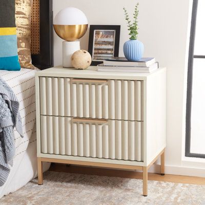 A clean-lined nightstand like this one takes a unique vintage style and makes it effortlessly mod. It rests on straight metal corner legs, while the rest of the piece is engineered wood in a muted tone. The two drawer fronts feature fluted details and metal hardware, making it easy to tuck away all your bedtime essentials. Measuring just over 22" wide, this bedside table fits neatly next to your bed or living room sofa. Color (Top/Base): Bleached White | Joss & Main Burgess 2 - Drawer Nightstand Side Tables Bedroom Modern, Unusual Bedside Tables, Nyc Room, Stylish Nightstand, Bedside Essentials, Safavieh Furniture, Spindle Dining Chair, Bedside Table Design, Modern Bedside Table