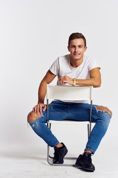 A man in jeans sits on a chair backwards and and ripped jeans T-shirt front view #Ad , #sponsored, #ripped, #shirt, #front, #view Sitting Backwards On Chair Pose, Sitting On Chair Backwards, Sitting Pose Front View, Posing Reference, Ripped Shirt, Male Photographer, Men Poses, Chair Photography, Jeans And T Shirt Outfit