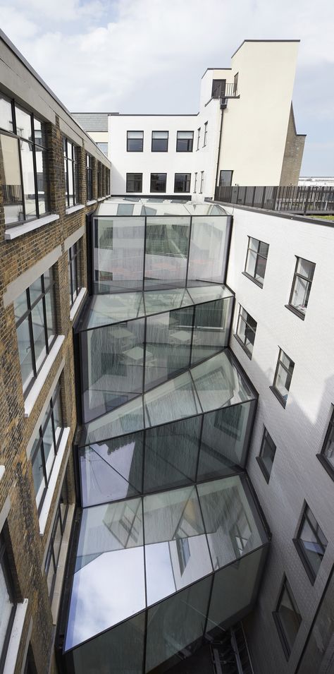 The unique new atrium on this office development provides a physical link between an old building, built in 1904 as Marks and Spencer’s HQ, and its 1936 addition. With glass walls on each level set at different planes, every step taken through the building promises a completely different aspect. A truly dynamic space. #architecture #england #glazing #rural #extension #cantifix Old Building With New Addition, Building Addition Architecture, Old Building Extension, Architecture Between Buildings, Architecture Extension Projects, In Between Spaces Architecture, In Between Space Architecture, Building Extension Architecture, Dynamism Architecture