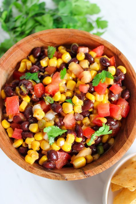 This Black Bean and Corn Salsa takes just 10 minutes to make and is the perfect easy snack or appetizer on hot summer days! This easy recipe combines black beans, Mexican corn, green onions, and tomatoes with a zesty lime dressing. Perfect for parties, picnics, or a healthy snack, serve it with chips for a delicious treat. Beans Mexican, Black Bean And Corn Salsa, Pork Chop Marinade, Onions And Tomatoes, Corn Salsa Recipe, Black Bean And Corn, Black Beans Corn, Black Bean Corn, Mexican Corn