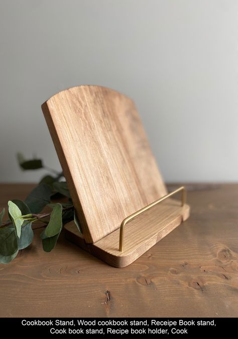 This rustic yet elegant cookbook stand adds charm to anyone's kitchen. A perfect gift for any cook! Specifications: - Handcrafted from solid pine - Choose from 4 stains, shown in walnut with gold - Metal bar detail available in black or gold - Approximately 9" Wide x 11" Tall Instagram @267company www.267company.ca ~ Colours~ Each item is handcrafted and made to order so item may look slightly different than the picture due to wood grain/ knots e Wooden Stand For Kitchen, Cookbook Holder In Kitchen, Cookbook Stand In Kitchen, Recipe Book Holder In Kitchen, Diy Cookbook Stand, Wood Cookbook Stand, Bookshop Ideas, Diy Book Stand, Wooden Cookbook Stand