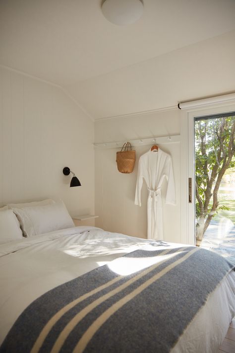 Lisa Jones' Shelter Island House Guestroom with Peg Rails, Photo by Jonathan Hokklo -- simple guest room Zen Guest Room, Shaker Peg Rail Bedroom, Minimal Beach Bedroom, Peg Rail Bedroom, Small Room Big Bed, Simple Guest Room, Peg Rails, Guest Bedroom Colors, Outdoor Living Deck