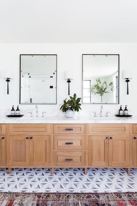 A golden oak dual washstand accented with oil rubbed bronze hardware sits on white and gray marble mosaic floor tiles beneath black framed vanity mirrors lit by oil rubbed bronze sconces. Jack N Jill Bathroom Ideas, Marble Mosaic Floor, Windows Design, Black Vanity Bathroom, Black Mirror Frame, Bathroom Cabinetry, Oak Bathroom, Transitional Bathroom, Jack And Jill Bathroom