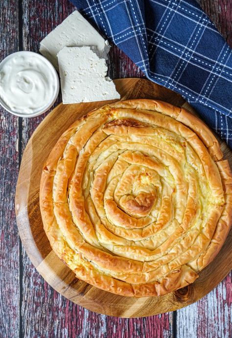 Aerial view of Banitsa (Bulgarian Cheese Pie) on a wooden board next to yogurt and cheese. Phyllo Recipes, Bosnian Recipes, Cheese Buns, Cheese Pie, Wooden Food, Cheese Pies, Bulgarian Recipes, Tortilla Recipe, Pork Meat