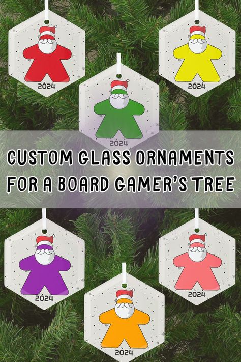 For the family members and friends who love to play tabletop games, these hexagon shaped glass ornaments will make a welcome addition to the Christmas Tree this holiday season!  What color do they play?  You will find that color meeple here, there are 6 to choose from.  The little meeples are wearing santa hats and beards and are ready to decorate for Christmas.  A great stocking stuffer for a board game geek, you can easily personalize it with their name or the year. Personalized Board Games, Decorate For Christmas, Personalized Board, Board Game Geek, Santa Hats, Custom Glass, Hexagon Shape, Gaming Gifts, Tabletop Games