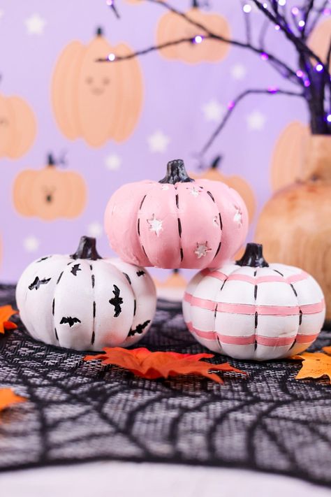 Add a touch of whimsy to your home with these 4" resin pumpkins. Available in 3 styles - white with black bats, white with pink stripes, or pink with white moons and stars - these pumpkins are perfect for your fall decor. Choose your favorite or mix and match for a unique look! Dimensions: 4 x 4 x 3" Top Shelf Decor, Pastel Resin, Black Pumpkins, Pumpkin Idea, Overall Skirt Denim, Moons And Stars, Halloween Pumpkin Designs, Creative Pumpkins, Black Pumpkin