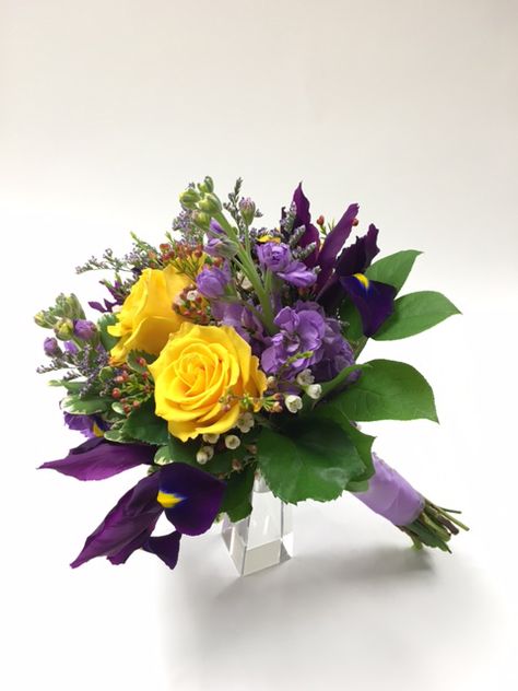 This beautiful spring attendants bouquet has purple irises, lavender stock, yellow roses and white wax flower. Purple And Yellow Bridal Bouquet, Purple And Yellow Wedding Flowers, Purple And Yellow Bouquet, November Bouquet, Iris Wedding Flowers, Yellow Wedding Flowers Bouquet, Purple And Yellow Wedding, Purple Roses Wedding, Lavender Stock