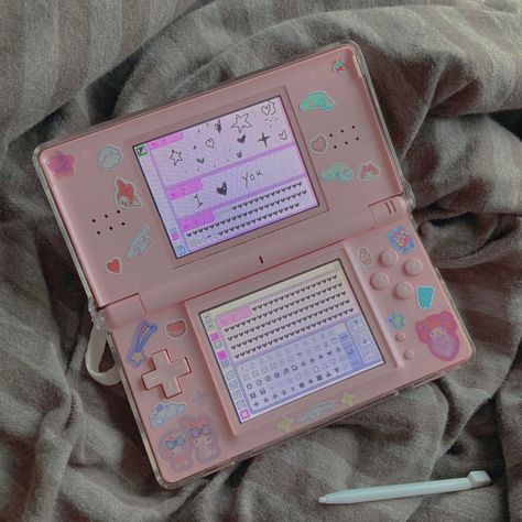 i bought a pink nds lite and put stickers on it :D im planning to get the sega card reader to play love and berry on it. Ds Lite Pink, Pink Ds Aesthetic, Pink Ds Lite, Nintendo Ds Decoration, Nintendo Ds Lite Aesthetic, Ds Lite Aesthetic, Playing Games Aesthetic, Nintendo Ds Aesthetic, Pink Nintendo Ds