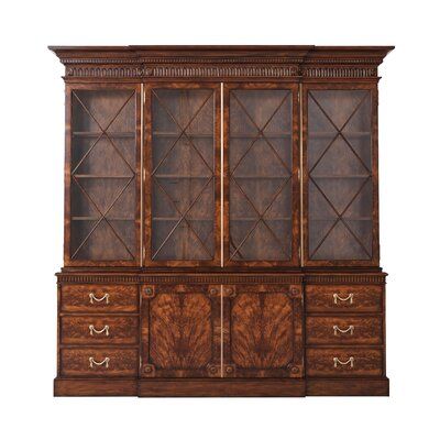 A mahogany and flame veneered breakfront bookcase, the upper sections with a molded cornice above a fluted frieze ornamented with dentils and oval rosettes, the bold diamond lattice astragal glazed doors enclosing reeded edge shelves above two cupboard doors, each flanked by three short drawers with swag drop handles on a plinth base. | Brown Wood Library Bookcase | Theodore Alexander Althorp Living History 96.5" H x 96.75" W Library Bookcase Wood in Brown, Size 96.5 H x 96.75 W x 18.0 D in | Wa Bookcase With Drawers, Breakfront Bookcase, Glazed Doors, Library Bookcase, Office Bookcase, Luxury Furniture Brands, Etagere Bookcase, Theodore Alexander, Wood Bookcase