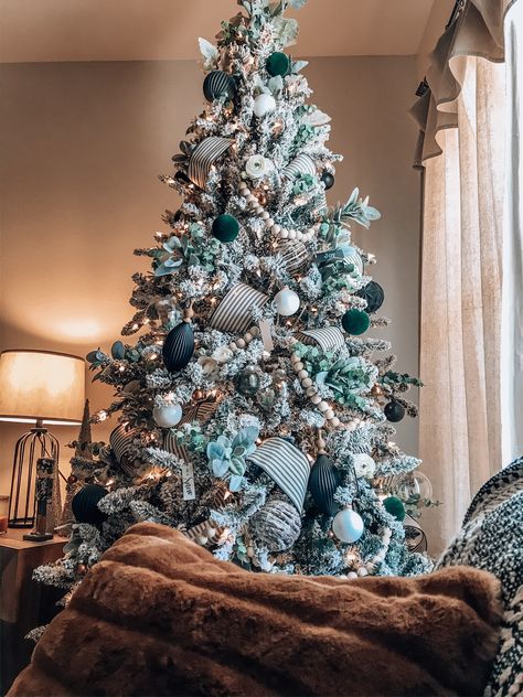 Christmas Tree Ideas 2022 Trends Green, Christmas Tree Ideas Emerald Green, Turquoise Decorated Christmas Tree, Light Blue And Green Christmas Tree, Green Aesthetic Christmas Tree, Green And Wood Christmas Tree, Bohemian Christmas Trees, Flocked Christmas Tree With Green Decor, Flocked Christmas Tree Green Ornaments