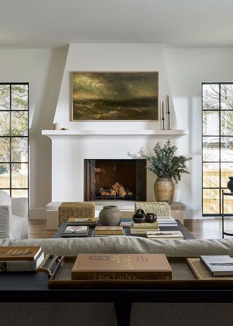 A Samsung Frame TV hangs over a white plaster fireplace mantel finished with a hearth and flanked by tall windows. White Plaster Fireplace, Tudor Fireplace, Tudor Renovation, Plaster Fireplace, Windsor House, Living Tv, Tall Windows, Living Room Renovation, Transitional Living Rooms