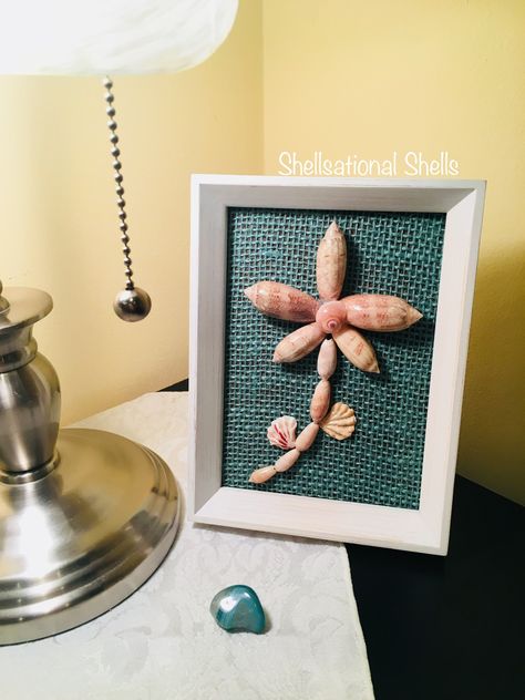 Brand new creation... Blooming Olives 🐚 This cute olive shells flower design is looking for a new home...the frame can stand alone or be hanged on a wall. PM me for details if interested. Frame Dimensions: 6”W x 8”H Shells: Lettered Olives and Kitten’s Paws Background: Aqua Burlap Olive Shell Crafts Seashells, Olive Shells Crafts, Lettered Olive Shell Crafts, Olive Shell Art, Olive Shell Crafts, Lettered Olive Shell, Shell Windchimes, Shells Crafts, Olive Shell