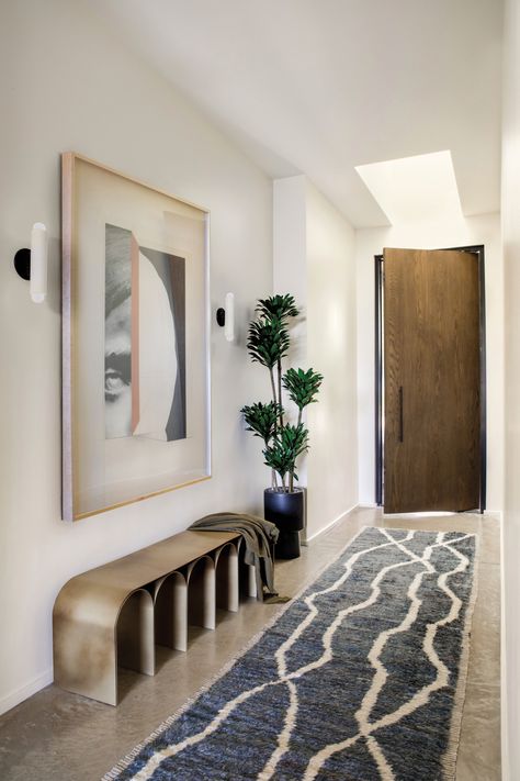 Designer Jen Samson mixed a vintage Moroccan runner from Katie Leede & Company with a striking brass bench by Pietro Franceschini in the entry of this Mar Vista home. Workstead sconces highlight Leigh Wells’ Visage 06 sourced from Tappan Collective. Modern Entryway Decor, Headboard Crafts, Wall Bench, Sleek Decor, Entry Bench, Modern Entryway, Beni Rugs, Headboard Wall, Architecture Home