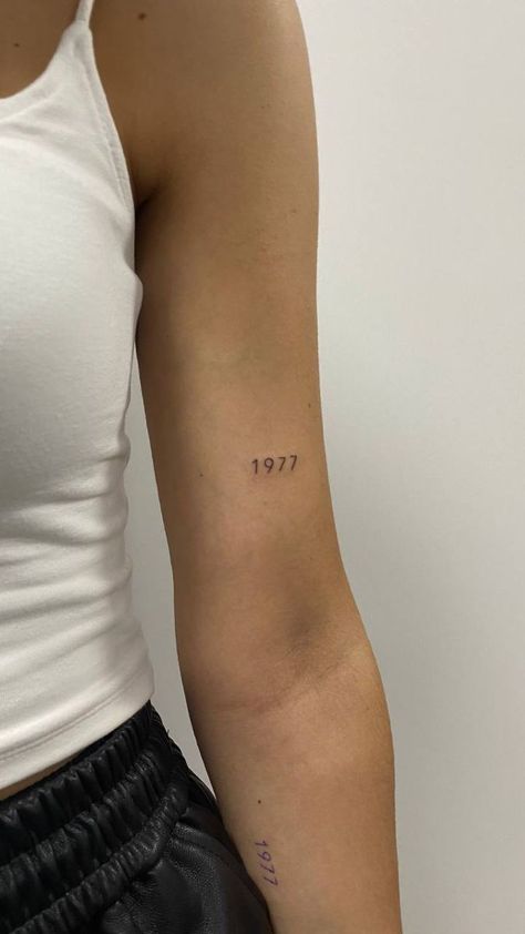 Date Placement Tattoos, Minimalist Tattoo On Arm For Women, Above Arm Tattoo, Date On Back Of Arm Tattoo, Dainty Tattoos Year, Year Tattoo Number Dainty, Mini Date Tattoo, Medium Tattoo Ideas Men, 1964 Tattoo Number Font