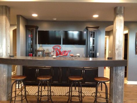 Basement Bar.  Rustic meets modern.  Custom cabinetry, Steelskin floating bar with Barnwood covered posts. Bar With Columns, Basement Bar Rustic, Modern Basement Bar, Basement Home Office, Wet Bar Basement, Rustic Basement Bar, Rustic Meets Modern, Floating Bar, Basement Bar Plans