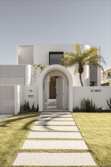 This Mediterranean inspired home features a paved footpath leading to a grand arch door entrance. Arch Door Entrance, Brushed Nickel Tapware, Nickel Tapware, Taj Mahal Quartzite Countertops, Abi Interiors, Mediterranean Homes Exterior, Arch Door, Taj Mahal Quartzite, Mediterranean Interior Design