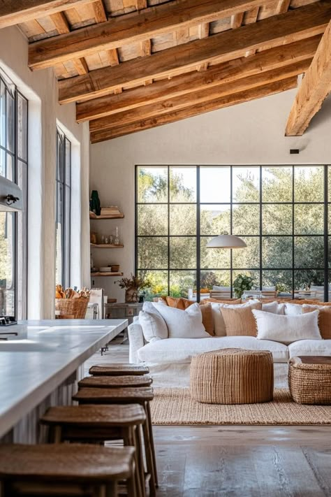 Modern farmhouse interior open plan with rustic beams large windows overlooking orange trees. Get inspired by all of these modern farmhouses that blend rustic charm with sleek, contemporary design for a cozy yet sophisticated home. Rural House Interior Design, Farm Style House Interior Rustic, Contemporary Style Homes Interiors, Modern Farmhouse Mansion Interior, American Modern House Interior, Spanish Beach House Interior, Spanish Farmhouse Living Room, Farm Modern House, Cozy Farm Home