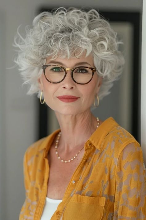 Elegant older woman with stylish curly gray hair, wearing glasses, pearl necklace, and a yellow patterned blouse. Short Curly Hair Styles For Older Women, Short Curly Hairstyles For Women Over 60, Short Naturally Curly Hairstyles, Curly Hairstyles For Square Faces, Grey Hair Inspiration Short Hairstyles, Short Curly Hair Inspiration, Short Curly Gray Hair Over 50 Curls, Short Curly Haircuts For Women, Curly Grey Hair Natural Curls