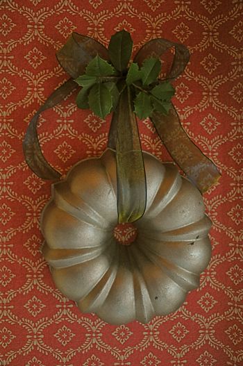 This idea isn’t anything novel but it’s still a good one. A round metal bundt cake pan takes the place of the traditional evergreen wreath. Ribbon from Micheal’s. (Photo- Martha B… Tart Tins, Bundt Pans, Bundt Cake Pan, Easy Christmas Wreaths, Kitchen Wares, Jello Molds, Antique Kitchen, Bundt Pan, Primitive Christmas