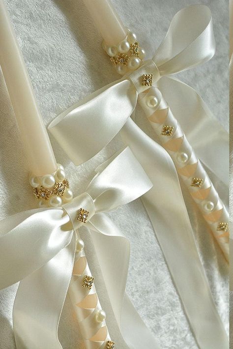 "This elegant and traditional set of 18\" Greek Orthodox Wedding Candles are perfect for your Greek Orthodox Wedding Ceremony.  Featuring ivory pearl beads and gold rhinestone accents on Ivory 18\" Dripless Taper Candles wrapped in ivory satin ribbon.   Also available in 24 Inch, Convo me for details and cost. Orders take 2 weeks to process and ship, if needed sooner rush options are available from the drop down menu. Personalized Printed Ribbons may be added to the back of your crowns or to you Debut Candles Design, Greek Orthodox Easter Candles, Baptismal Theme, Debut Candles, Orthodox Wedding Candles, Greek Wedding Candles, Dripless Taper Candles, Orthodox Candles, Corpus Cristi